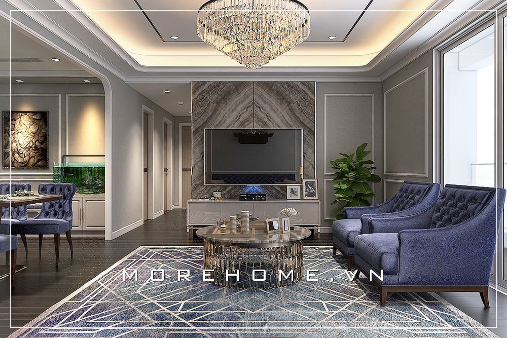 Mẫu thiết kế phòng khách chung cư tân cổ điển,gấy ấn tượng với hai ghế sofa đơn màu xanh độc đáo kết hợp với đá ốp vách ti vi màu nâu sữa vân mây mang đến không gian phòng khách sang trọng
