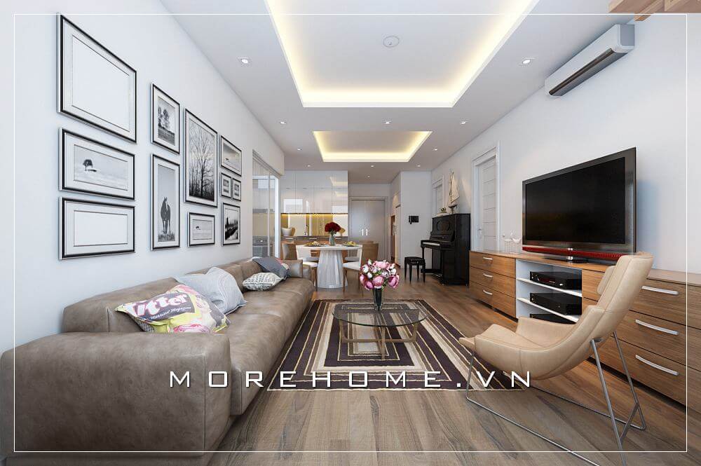 Sắc trắng nổi bật kết hợp sofa bọc da nâu trầm tạo nên vẻ đẹp sang trọng, độc đáo cho không gian phòng khách liền bếp căn hộ chung cư. Thiết kế phòng khách